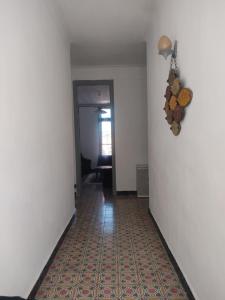 a hallway with a white wall and a clock on the wall at Appartement 3 pièces in LʼAgha +2 photos