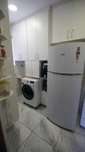 a kitchen with a refrigerator and a washing machine at Apartamento Centro São Carlos in São Carlos