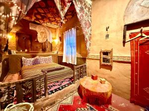 a bedroom with a bed and a table in it at Kasbah Maktob Tamnougalt in Agdz