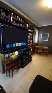 a living room with a large flat screen tv at Apartamento Centro São Carlos in São Carlos