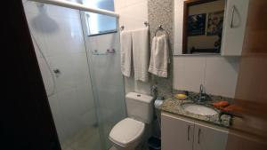 a bathroom with a toilet and a shower and a sink at Apartamento Centro São Carlos in São Carlos