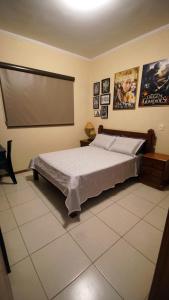 a bedroom with a large bed and a projection screen at Apartamento Centro São Carlos in São Carlos