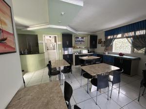 a kitchen with tables and chairs in a room at Pousada Rio Doce in Olinda +17 photos