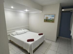 a bedroom with a bed and a painting on the wall at Pousada Rio Doce in Olinda