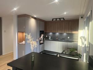 a kitchen with a black table with a vase of flowers at Newly built 2-Bed Flat with parking in Pully in Pully