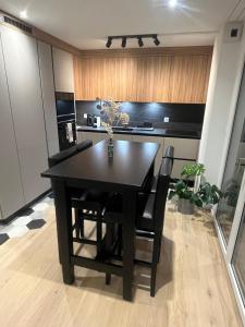 a black dining room table and chairs in a kitchen at Newly built 2-Bed Flat with parking in Pully in Pully