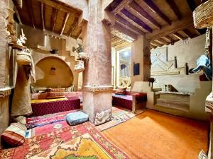 a large room with a pillar and a room with a rug at Kasbah Maktob Tamnougalt in Agdz +30 photos