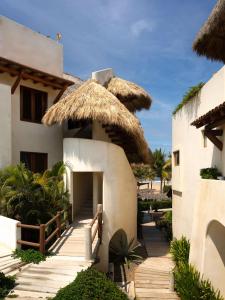 a house with a straw umbrella on the beach at Stunning, Oceanfront Casa de Olas in Ixtapa-Zihuatanejo International