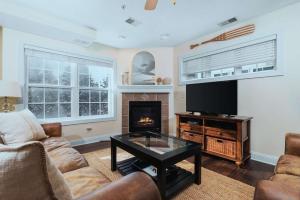 a living room with a couch and a tv and a fireplace at Bay Park 32: Downtown Condo! in Traverse City