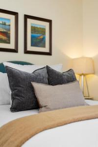 a bed with black and white pillows on it at Bay Park 32: Downtown Condo! in Traverse City