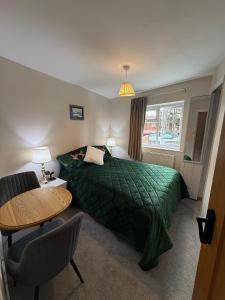 a hotel room with a green bed and a table at The Marsh Harrier B&B in Oxford