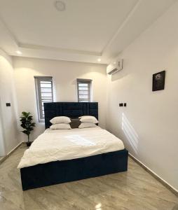 a bedroom with a large bed in a white room at Dinems Apartment in Ikeja +2 photos