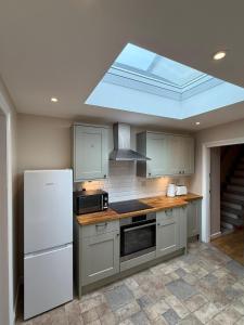 a kitchen with a white refrigerator and a skylight at The Marsh Harrier B&B in Oxford
