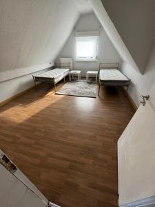 a attic room with two beds and a window at Schelder Unterkunft in Dillenburg