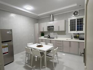 a kitchen with a white table and chairs in it at رحاب قريش in Al Masfalah
