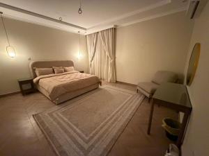 a bedroom with a bed and a chair and a desk at رحاب قريش in Al Masfalah