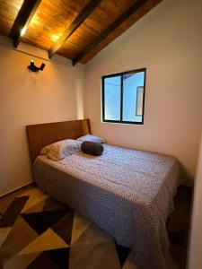 a bedroom with a bed and a window at Nido de Montaña Cabañas in Bello