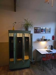 a green cabinet with a table and a table at Herberg Hanenberg in Wissenkerke