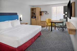 a hotel room with a bed and a table at Hampton Inn Chicago-Carol Stream in Carol Stream +38 photos