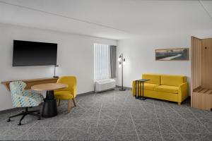 a living room with a table and a yellow couch at Hampton Inn Chicago-Carol Stream in Carol Stream