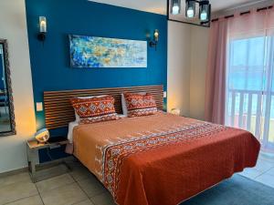 a bedroom with a bed and a blue wall at Beach front luxury living - 2 bedroom condo with sea view in Jan Thiel