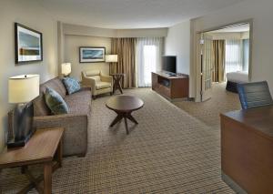 ein Hotelzimmer mit Sofa, Bett und Fernseher in der Unterkunft DoubleTree by Hilton Hotel & Conference Centre Regina in Regina