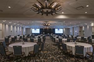 ein Konferenzraum mit Tischen und Stühlen und einem Kronleuchter in der Unterkunft DoubleTree by Hilton Hotel & Conference Centre Regina in Regina