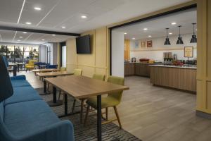 a dining room with tables and chairs and a kitchen at Hampton Inn - York in York