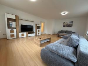 a living room with a couch and a tv at Home4You Hamburg-Neugraben EG in Hamburg