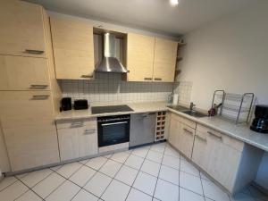 a kitchen with a sink and a stove top oven at Home4You Hamburg-Neugraben EG in Hamburg