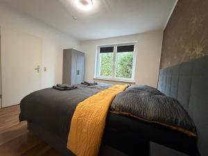 a bedroom with a large bed and a window at Home4You Hamburg-Neugraben EG in Hamburg