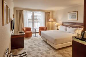 a hotel room with a bed and a desk and a window at Hilton Antwerp Old Town in Antwerp +109 photos