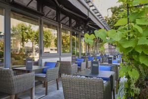 an empty restaurant with tables and chairs and windows at Hilton Antwerp Old Town in Antwerp
