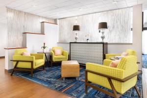 a waiting room with yellow chairs and a table at Hampton Inn Naples-Central in Naples