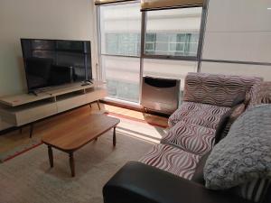 a living room with a couch and a flat screen tv at Departamento de lujo 2D Av Arce in La Paz