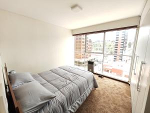 a bedroom with a bed and a large window at Departamento de lujo 2D Av Arce in La Paz