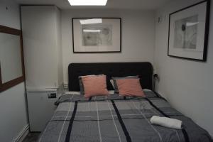 a bedroom with a bed with two pink pillows at Brabo 1 in Landskrona