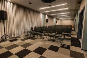 a room with a row of chairs and a podium at ibis Tangará Da Serra in Tangara da Serra