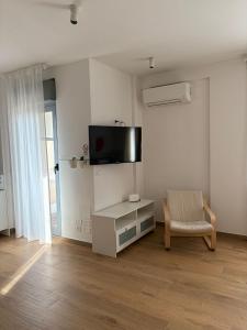 a living room with a chair and a tv on the wall at Solaria House in Montesilvano