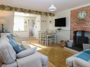 a living room with a couch and a fireplace at Herbies Cottage in Snettisham