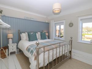 a bedroom with a bed and a window at Herbies Cottage in Snettisham