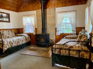 ein Schlafzimmer mit zwei Betten und einem Holzofen in der Unterkunft Rustic Cottages in Tahoe Vista