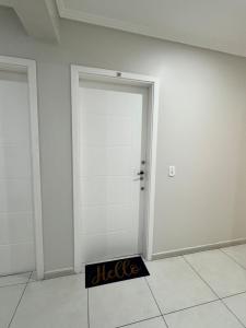 a white door with a black sign in front of it at Apê Família | Varanda c/ churrasqueira | Garagem in Ponta Grossa