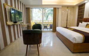 a hotel room with a bed and a chair and a balcony at Five Palms Hotel in Gurgaon