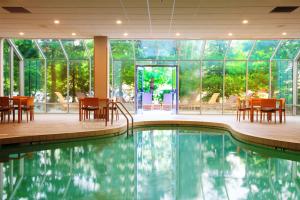 a pool in a hotel with tables and chairs and windows at Embassy Suites by Hilton Cincinnati Northeast - Blue Ash in Blue Ash