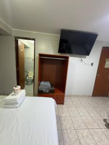 a bedroom with a bed and a flat screen tv at Hospedaje W TAWA in Lima +33 photos
