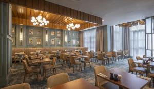 a dining room with tables and chairs and chandeliers at Hilton Dublin in Dublin