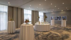 a conference room with tables with flowers on them at Hilton Dublin in Dublin