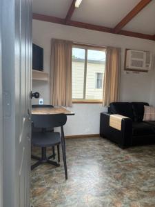 a living room with a table and a couch at Denman Van Village in Denman
