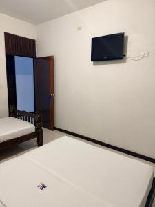 a room with a bed and a tv on the wall at Hotel Milenium in Yopal